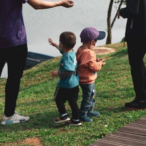 man in blue crew neck t-shirt and black pants holding girl in orange t-shirt
